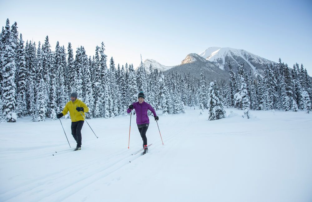 Two people having fun on cross country skis on the Great Divide Trail at Lake Louise